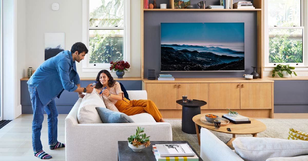 Couple in living room looking at devices together